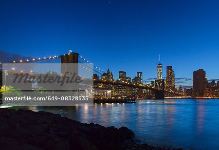 Manhattan financial district and Brooklyn bridge at night, New York, USA