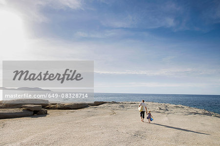 Mature man strolling with his toddler daughter on beach, Calvi, Corsica, France