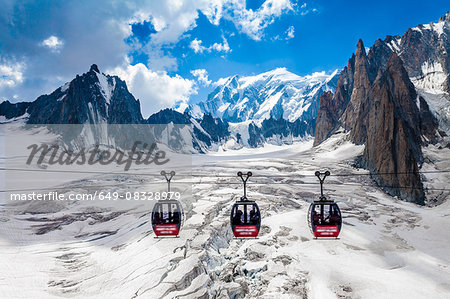 Elevated view of three cable cars over snow covered valley at Mont blanc, France