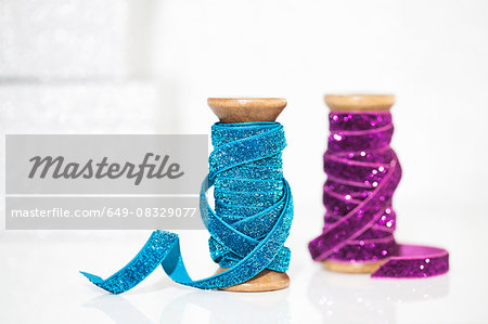 Wooden reels of sparkly blue and purple ribbon