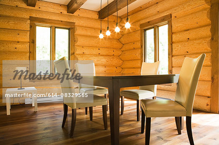 Dining table and chairs with modern lighting in Eastern white pine log cabin