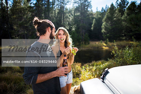 Young couple eating grapes on riverside, Lake Tahoe, Nevada, USA