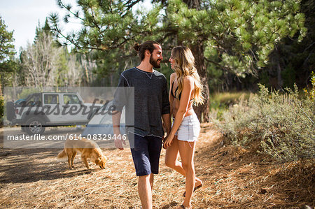 Romantic young couple holding hands in forest campsite, Lake Tahoe, Nevada, USA