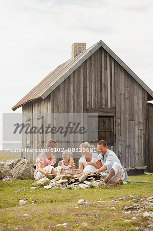 Family sitting near wooden house