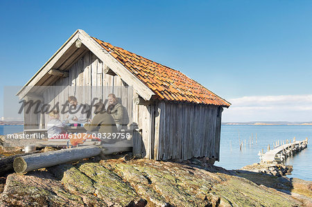 Family near wooden building at sea