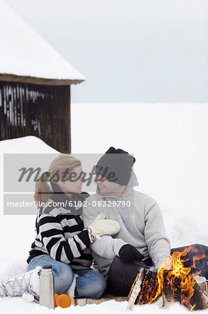Couple having campfire at winter