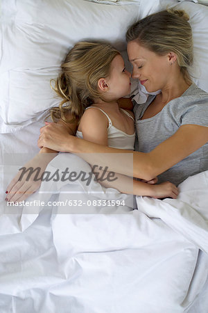 Mother and daughter in bed embracing