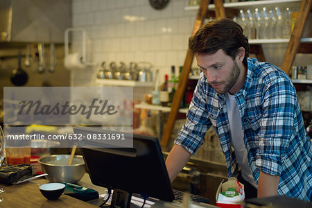 Cafe owner looking at cash register
