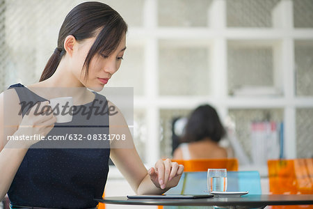 Woman relaxing in cafe with digital tablet