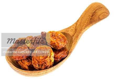 dried goldenberries on a small wooden spoon isolated on white