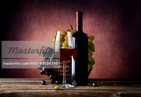 Red wine with basket of grape on table