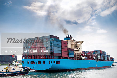 2 tug vessels pulling a loaded container ship from the port of Rotterdam, Netherlands