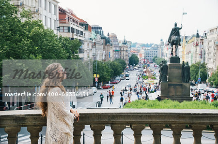 Longhaired bohemian woman tourist sightseeing on Wenceslas Square in Prague. In the background Saint Wenceslas statue in Prague. Tourism travel concept.