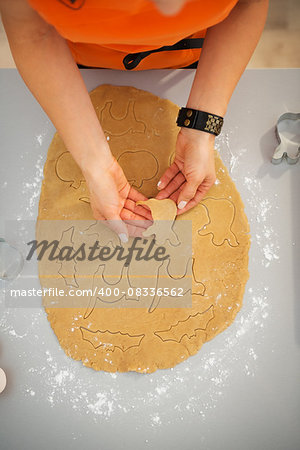 Closeup on woman making Halloween biscuits from rolled pastry in kitchen. Traditional autumn holiday. Upper view