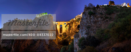 illuminated  Puente Nuevo Bridge from outskirts of Ronda at sunset, Spain. Panoramic view