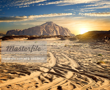 Rocks in sand desert in sunny evening