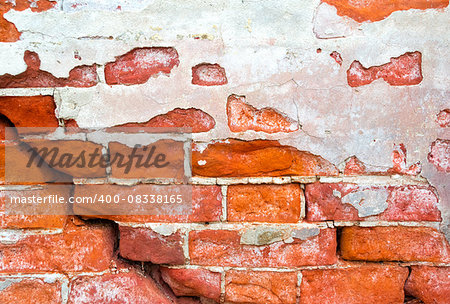 Brick cracked old weathered wall with an old plaster as a background