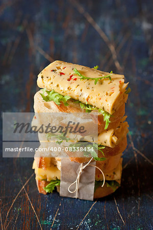 Pile of vegetarian cheese sandwiches on wooden background.