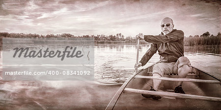 senior paddler enjoying paddling a canoe on a calm lake at sunset, a grunge texture finish in sepia tone