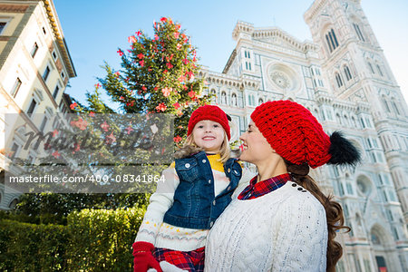 Happy mother and daughter standing near Christmas tree and Duomo in Florence, Italy. Modern family enjoying carousel of Christmas time events in heart of the Renaissance.