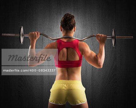 Muscular woman lifting an outrigger with weights