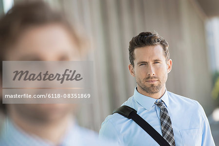 Two men, one in the foreground, and one in focus in the background.