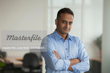 Singapore, Businessman standing in office with arms folded