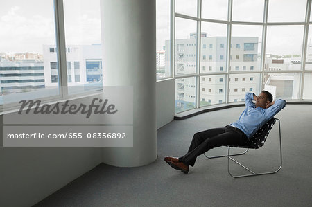 Singapore, Businessman sitting in chair in empty office
