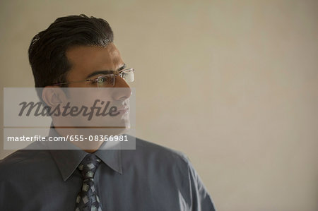 India, Portrait of businessman with glasses looking across room