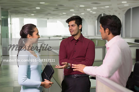 India, Colleagues standing in office and talking