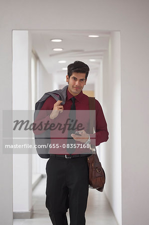 India, Young businessman walking down corridor