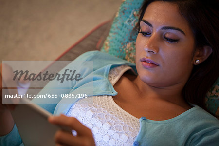 Singapore, Woman relaxing with digital tablet at night