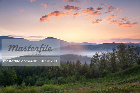 Stunning sunrise mountain landscape with vibrant colors and beautiful fog and clouds formations, summer time