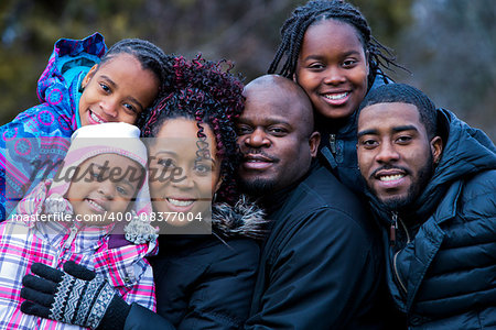 casual winter young black family outdoors in the park