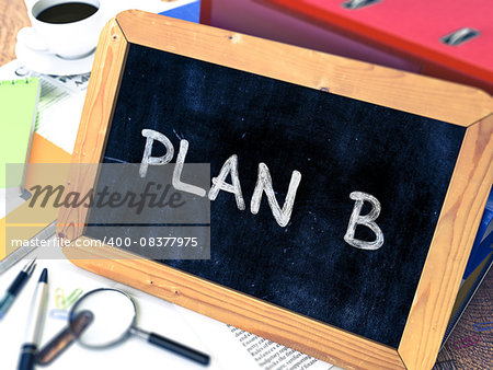 Plan B Handwritten on Chalkboard. Composition with Small Chalkboard on Background of Working Table with Ring Binders, Office Supplies, Reports. Blurred Background. Toned Image.