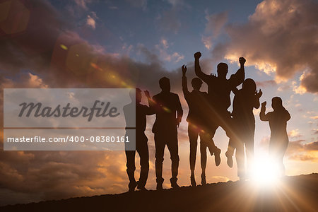 Silhouetters celebrating against clouds