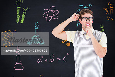Geeky hipster thinking with hand on chin against blackboard