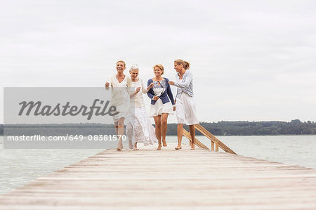 Group of female friends, walking on pier, laughing