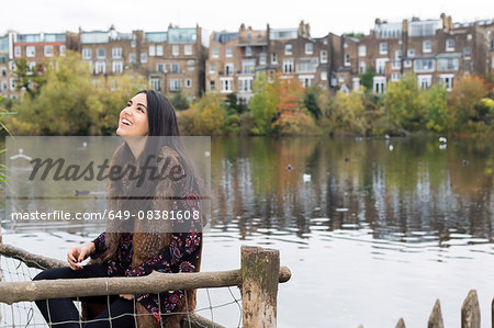 Young woman relaxing by lake, Hampstead Heath, London