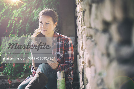 Mid adult woman using digital tablet in gardens at Thornbury Castle, South Gloucestershire, UK