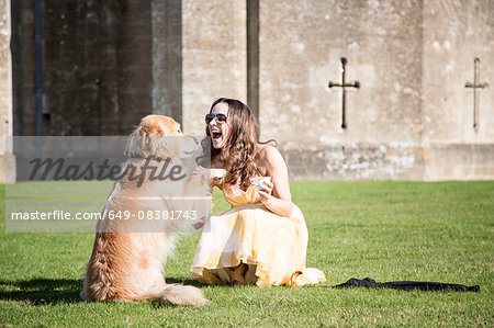 Woman posing with cup of tea and golden retriever dog at Thornbury Castle, South Gloucestershire, UK