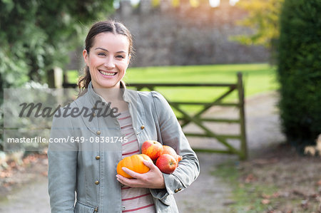 Portrait of woman holding apples and pumpkin at Thornbury Castle, South Gloucestershire, UK