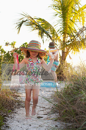 Girl and brother collecting seashells at beach, Sanibel, Florida, USA