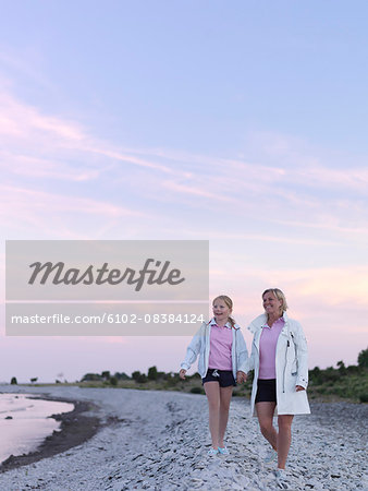 Mother with daughter walking on beach