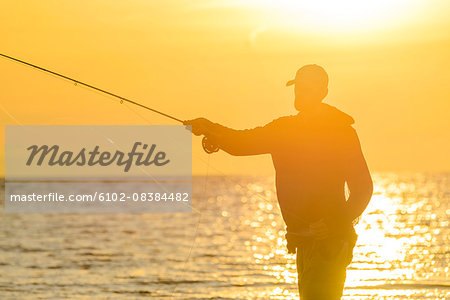 Silhouette of man fishing