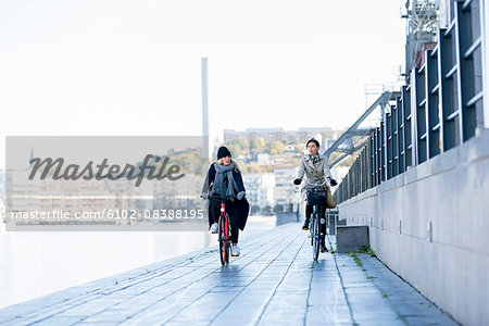 Women riding bicycles on promenade