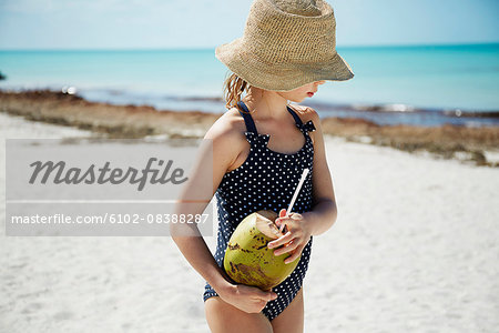 Girl with coconut drink on beach