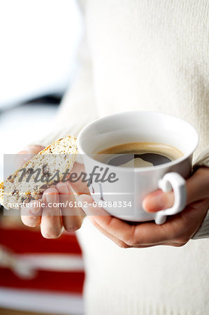 Woman holding coffee cup and cake