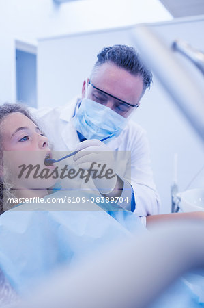 Pediatric dentist examining his young patient