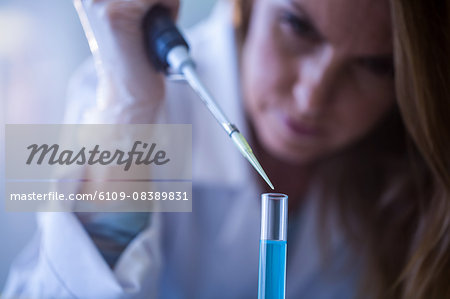 Scientist syringing chemical into test tube